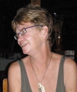 Photo of Patricia Kearney, a woman with tanned skin and short dark-blonde hair. She is wearing glasses and a tank top. She is looking off to the left of the photo.