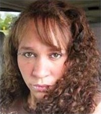 Photo of Barbara Getman, a Caucasian woman with curly brown hair and straight bangs that fall across her face.
