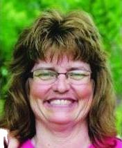 Photo of Peggy Schroeder, a middle-aged woman with wavy brown hair, fair skin, and glasses.