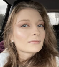 Photo of a young woman with pale skin and straight light-brown hair.