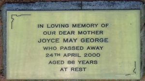 Plaque reading, "In loving memory of our dear mother Joyce May George, who passed away 24th April 2020, aged 86 years. At rest."
