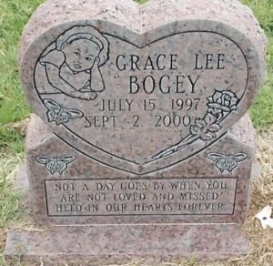 Photo: A heart-shaped pink granite gravestone, reading Grace Lee Bogey, July 15, 1997 to September 2, 2000. Not a day goes by when you are not loved and missed. Held in our hearts forever."