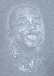 Engraved image of a young African-American boy with a wide smile, eyes squeezed nearly shut in amusement.