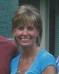 Photo of Ruth Pyne, a woman with layered blonde hair, tanned skin, and a teal V-neck shirt. She is smiling.