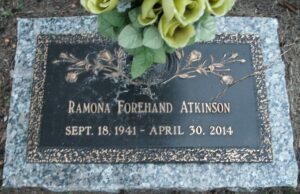 Photo of a gravestone reading, Ramona Forehand Atkinson, September 18, 1941 to April 30, 2014. An urn on the gravestone holds yellow silk flowers.
