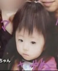 Photo of a Japanese toddler with short, shaggy black hair, her face solemn.