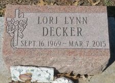 Photo of a pink granite gravestone that reads, Lori Lynn Decker, Sept. 16, 1969 - Mar. 7, 2015. The stone is decorated with a carved cross.