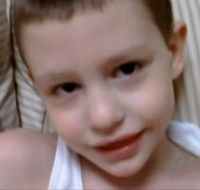 Photo of a boy with fair skin and sandy hair, wearing a white shirt.