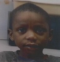Photo of a young boy with dark skin, large brown eyes, and short dark-brown hair.