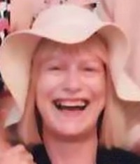 Photo of Julie Collier, a woman with straight blond hair, wearing a floppy hat. She is smiling.
