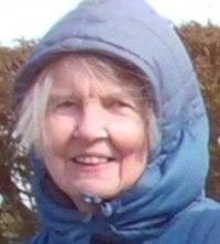 Photo of Meryl Parry. She is an elderly woman with fair skin and white hair. She is outdoors, wearing a blue coat with the hood up.