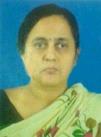 Photo of Shobhana, an Indian woman with her dark brown hair pulled back. She has light-brown skin and a bindi on her forehead, and is wearing a flower-print sari over a dark shirt.