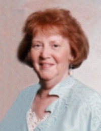 Portrait photo, slightly blurry, of a woman in late middle age. She has fair skin and red hair cut to chin length.