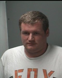 Photo of Justin Kirby. He is a man with ruddy skin and light brown hair, wearing a white sweatshirt. His hair is cut short; his expression is neutral.