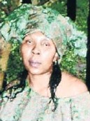 Photo of Refilwe Monamodi. She is a woman with light-brown skin and black hair that has been partly dyed green. She looks about middle aged.