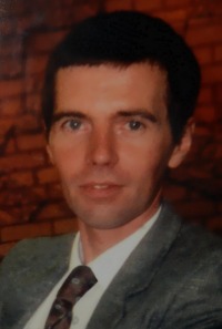 Photo of Paul Roddy, a man with fair skin and dark-brown hair. He is wearing a suit and tie.