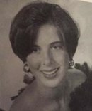 Sepia-tone photo of a young woman with short hair and big earrings.