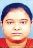 ID photo of an Indian woman with brown eyes, brown hair, and olive-toned skin, her hair pulled back; she is wearing a red shirt and her expression is neutral.