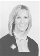 Black and white photo of Johanna Becker. She has light skin and neat, blond shoulder-length hair and is wearing a suit jacket and pearl necklace.