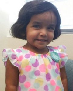 Photo of Sherin Mathews, a young girl with tan skin and chin-length brown hair, wearing a dress with pink polka-dots on it.