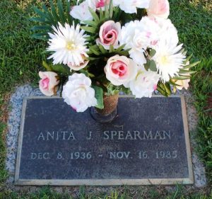 Photo of Anita Spearman's gravestone, which reads, "Anita J. Spearman, December 8, 1936 to November 15, 1985." There are flowers in an attached vase.