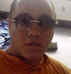 Photo of Murray Upshaw, a man with light skin, wearing sunglasses and an orange shirt. He is balding and little of his dark hair is visible.