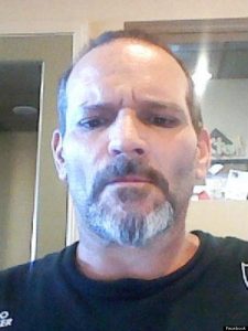 Photo of Michael Jones, a middle-aged man with light skin and brown eyes. He is balding and has a salt-and-pepper mustache and beard.