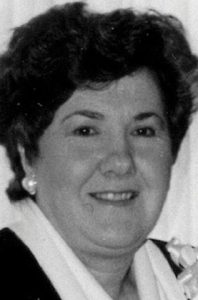 Black-and-white photo of Irene Carter, a woman with fair skin and dark curly hair, wearing pearl earrings.