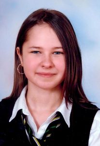 School photograph of Michelle Stewart, a girl with fair skin and long brown hair, wearing a school uniform and hoop earrings.