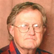 Photo of Bruce Clayton, a middle-aged man with thinning light-brown hair and fair skin, wearing glasses. He is wearing a flannel shirt, and frowning at the camera.