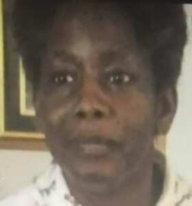 Photo of a middle-aged African-american woman with short curly black hair and dark-brown skin.