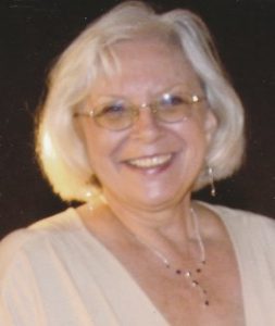 Photo of an older woman with white hair and pale skin, in a formal blouse and silver necklace.