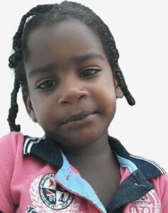 Photo of a girl in a pink school uniform. She has brown skin, and her dark hair is done in small braids.