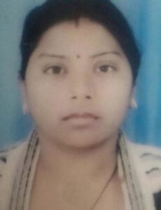 Photo of a young Indian woman with a bindi on her forehead, her hair tied behind her head.