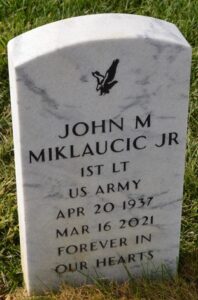 Photo of a white marble gravestone that reads, "John M. Miklaucic Jr., 1st Lt US Army, April 20, 1937 to March 16, 2021, forever in our hearts."