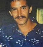 Photo of a man with a mustache, wearing a dark blue shirt.