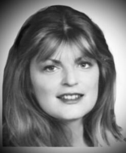 Black and white photo of a woman with light skin and moderately dark hair, smiling for the camera. 