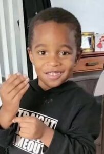 Photo of a small African American boy with short hair, wearing a black sweatshirt.