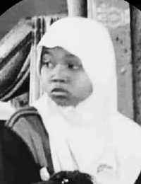 Black and white photo of a dark-skinned child in a white headscarf, looking off to the side with a concerned expression.