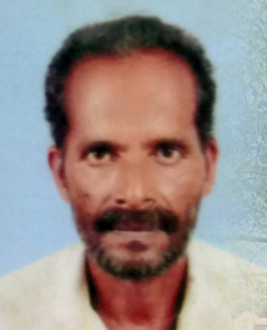 Photo of a middle-aged Indian man with short curly black hair, trimmed mustache and beard, and brown skin; he is wearing a white dress shirt.